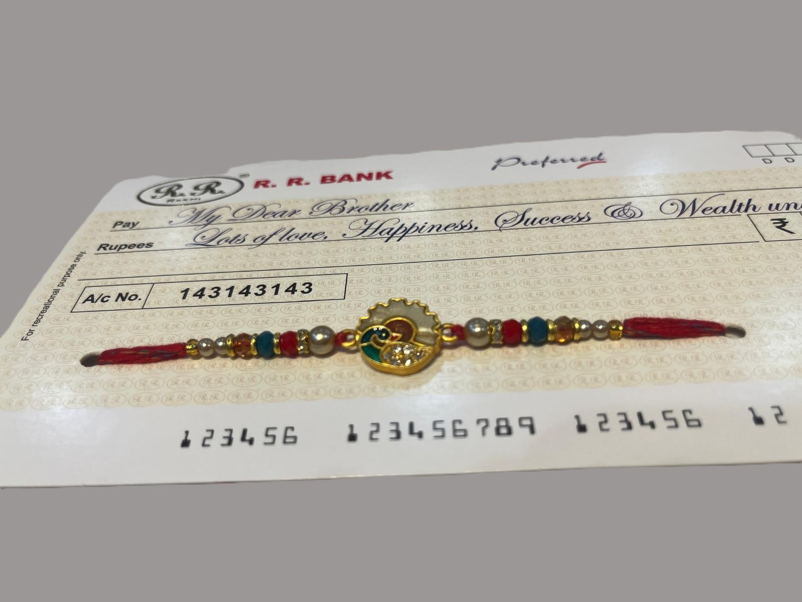 Elegant Peacock Pearl Rakhi & Novelty Shagun Cheque